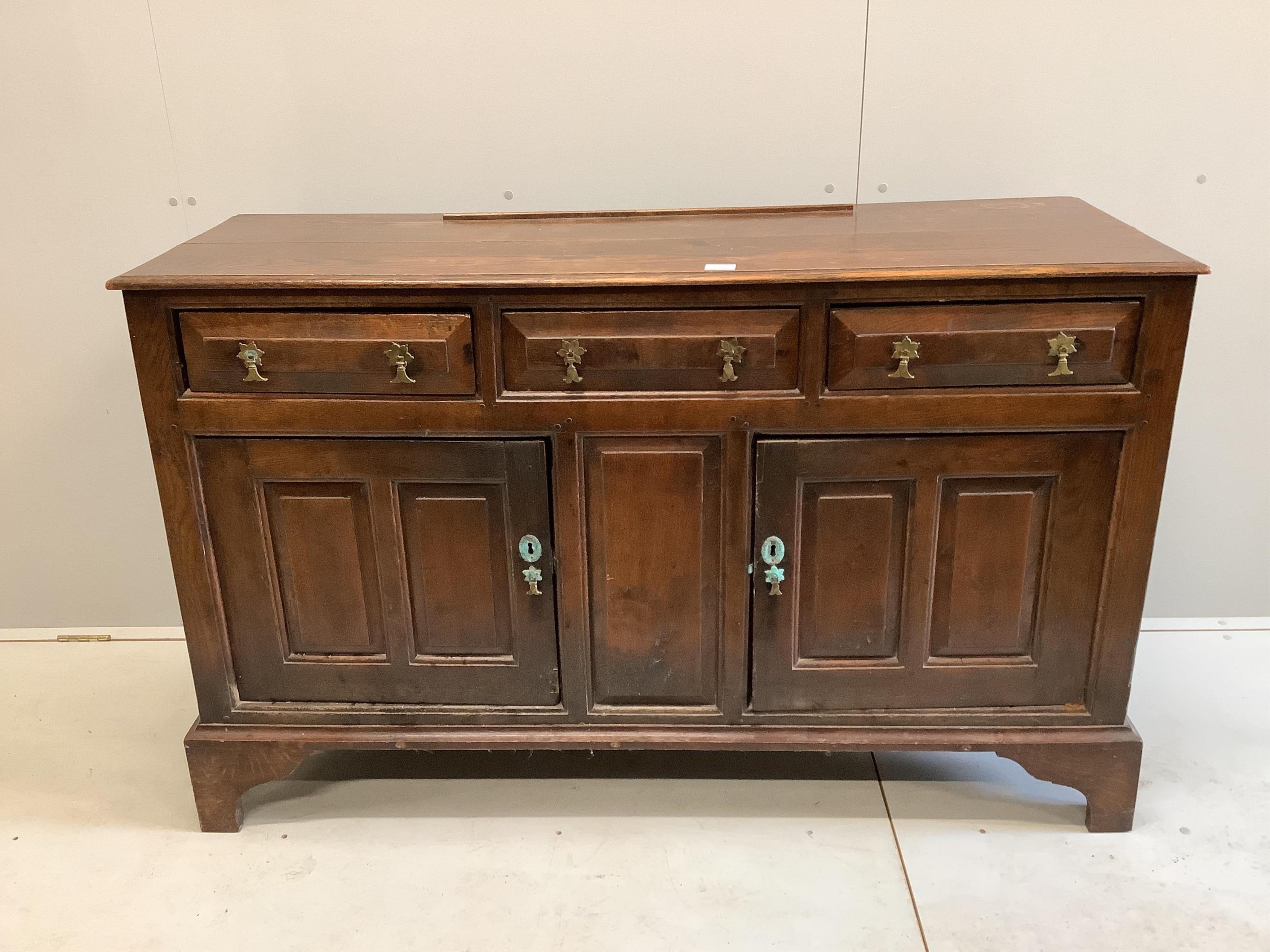 A mid 18th century oak dresser, with fielded panelled cupboards and drawers, width 143cm, depth 49cm, height 89cm. Condition - poor